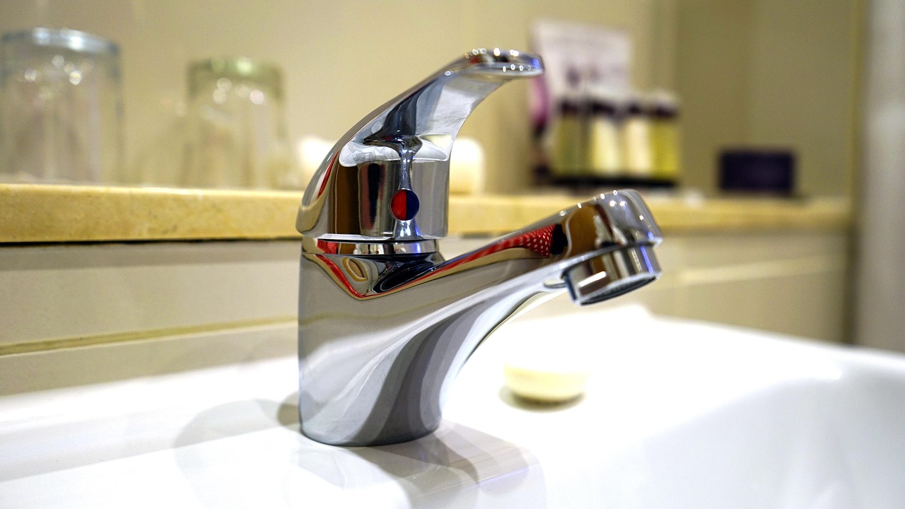 bathroom sink with tap and air freshener and soap on the side