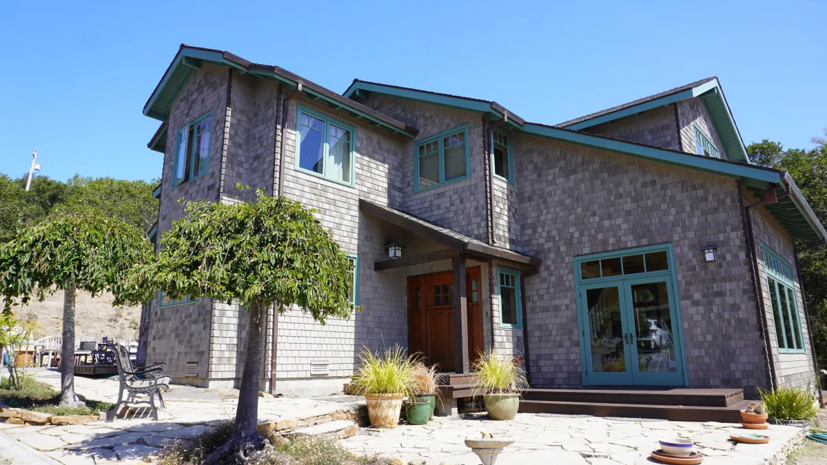 Exterior house with cedar shingles and weather grey painted with green trim in Bolinas, ca.