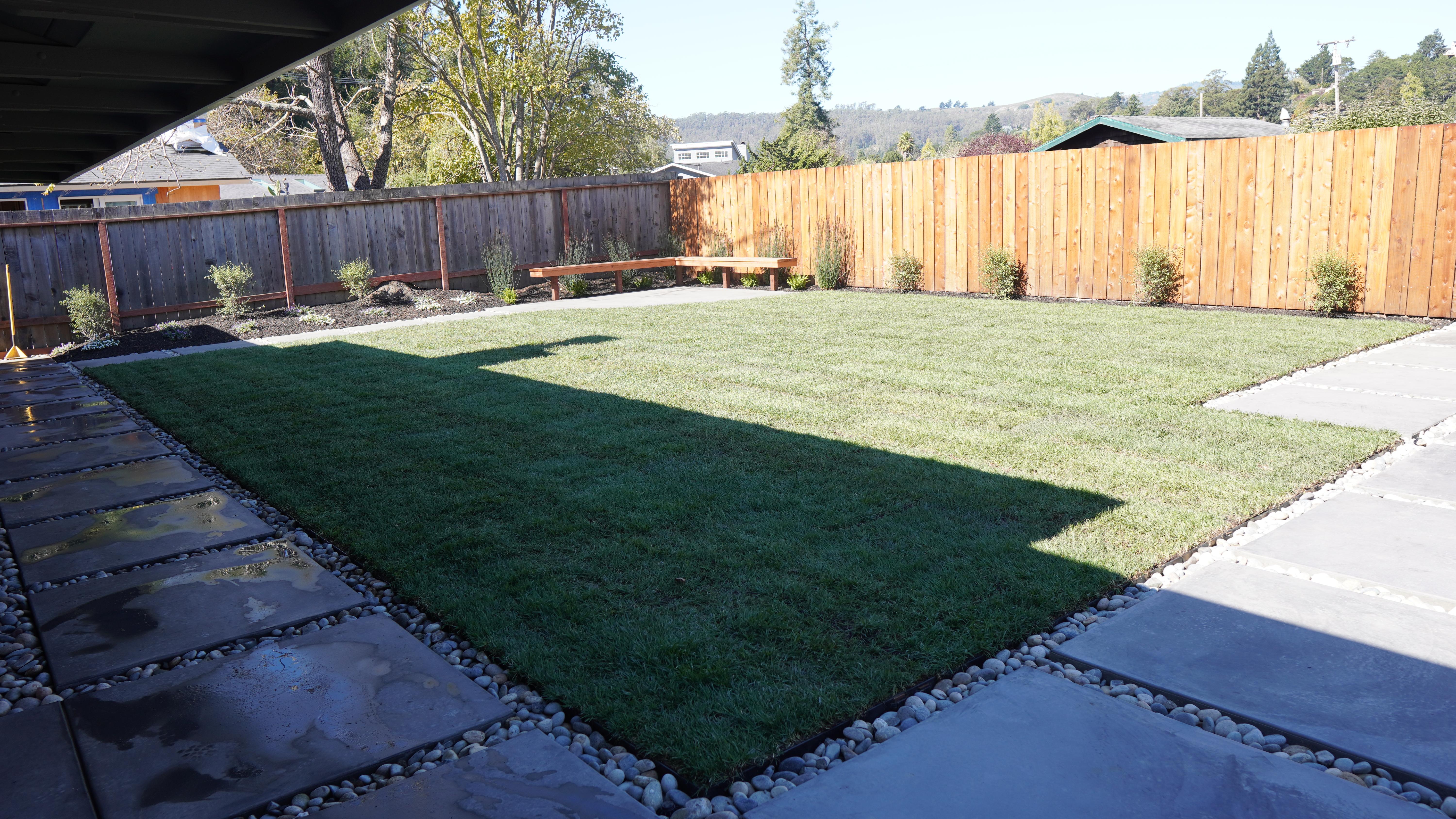 Back yard landscaping featuring new sod, paver paths and a bench in Mill Valley, CA.