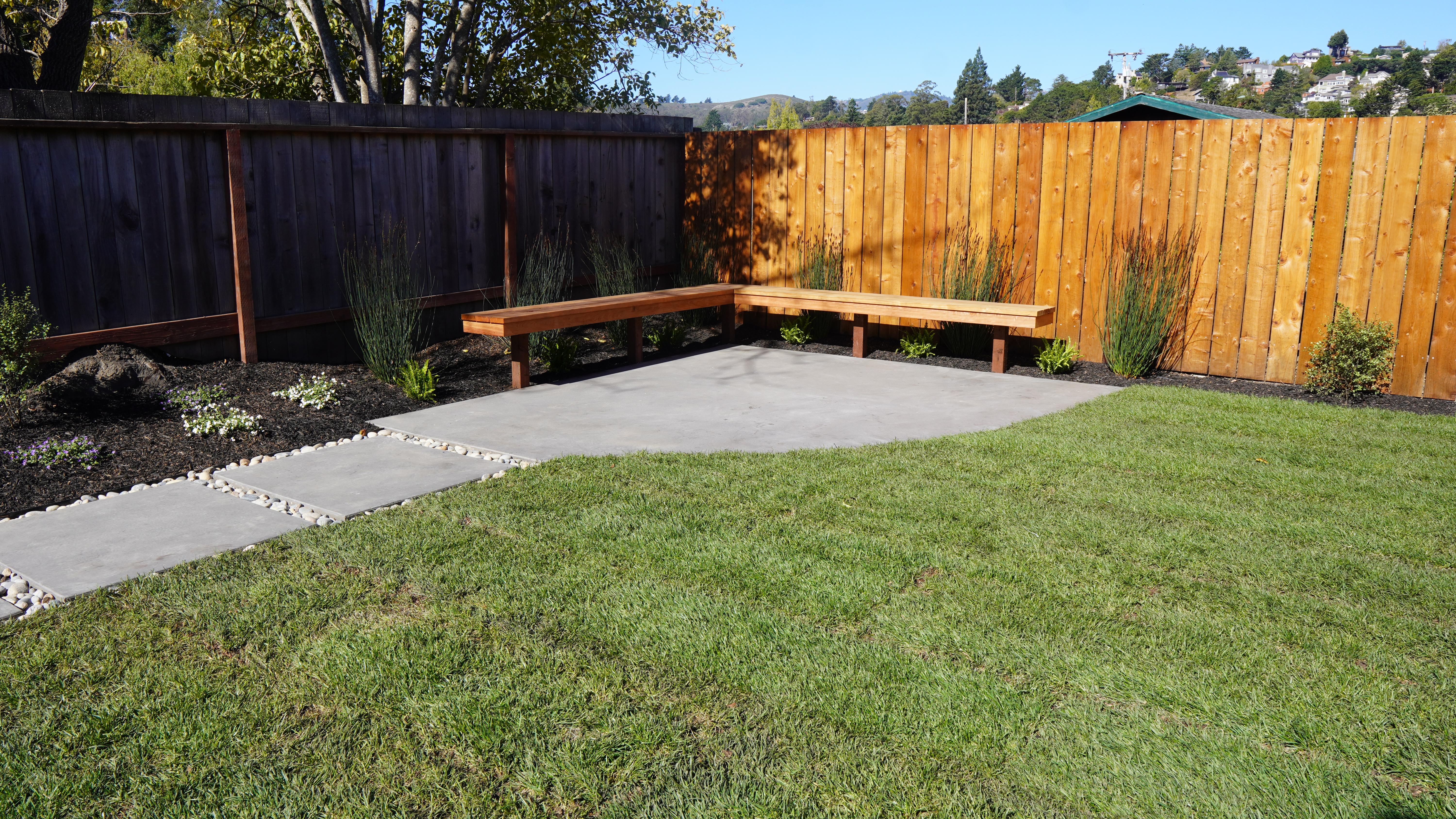 Wood bench on a corner of a back yard landscape in Mill Valley, CA.