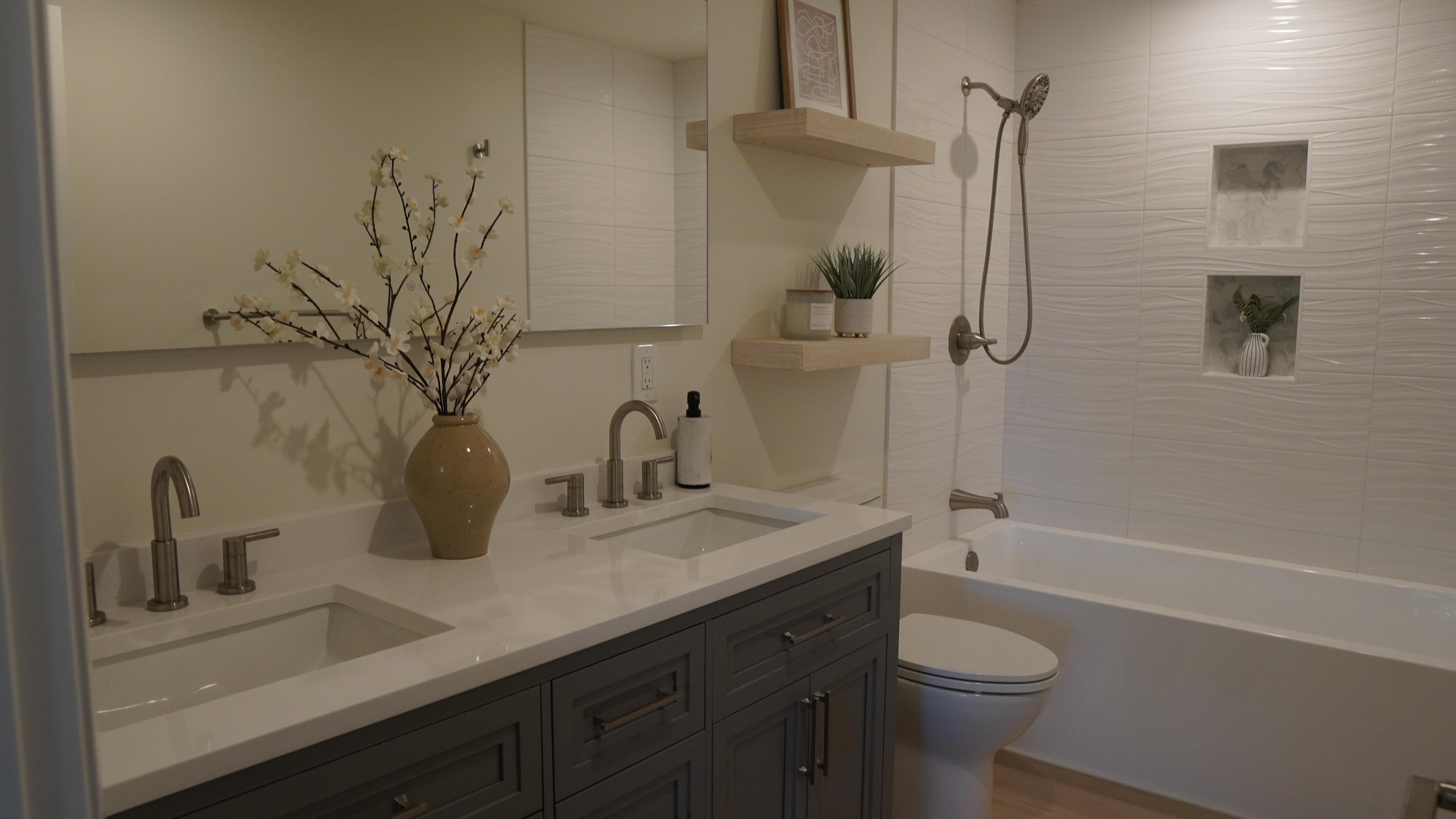 Bathroom remodel featuring a double sink vanity with stain-less steel facets in San Francisco, CA.