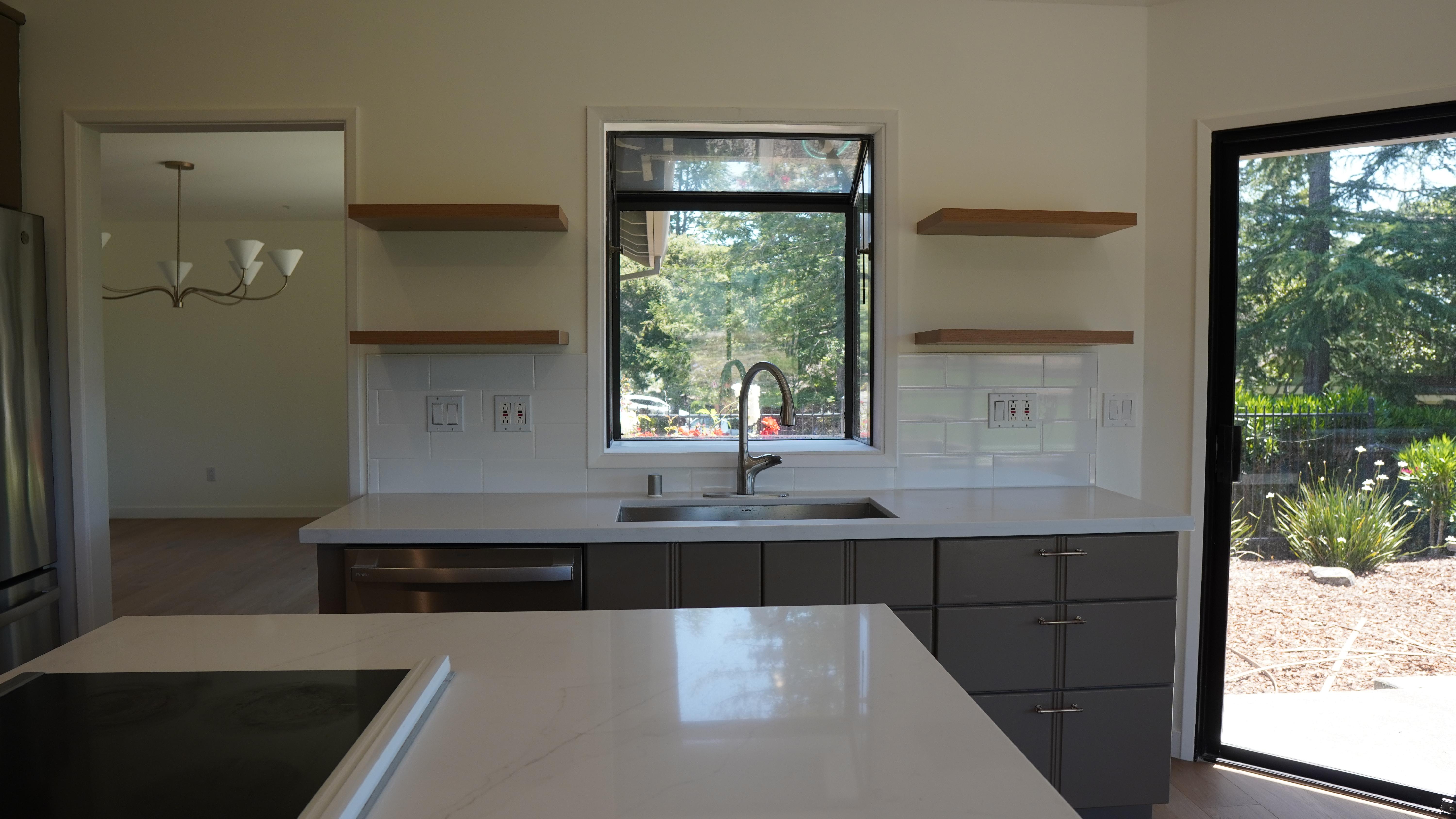 kItchen Remodel featuring sink cabinet, stain-less steel under mount sink and faucet, floating shelves on both side of he sink, window behind the sink, sliding window on the right side in Novato, CA.