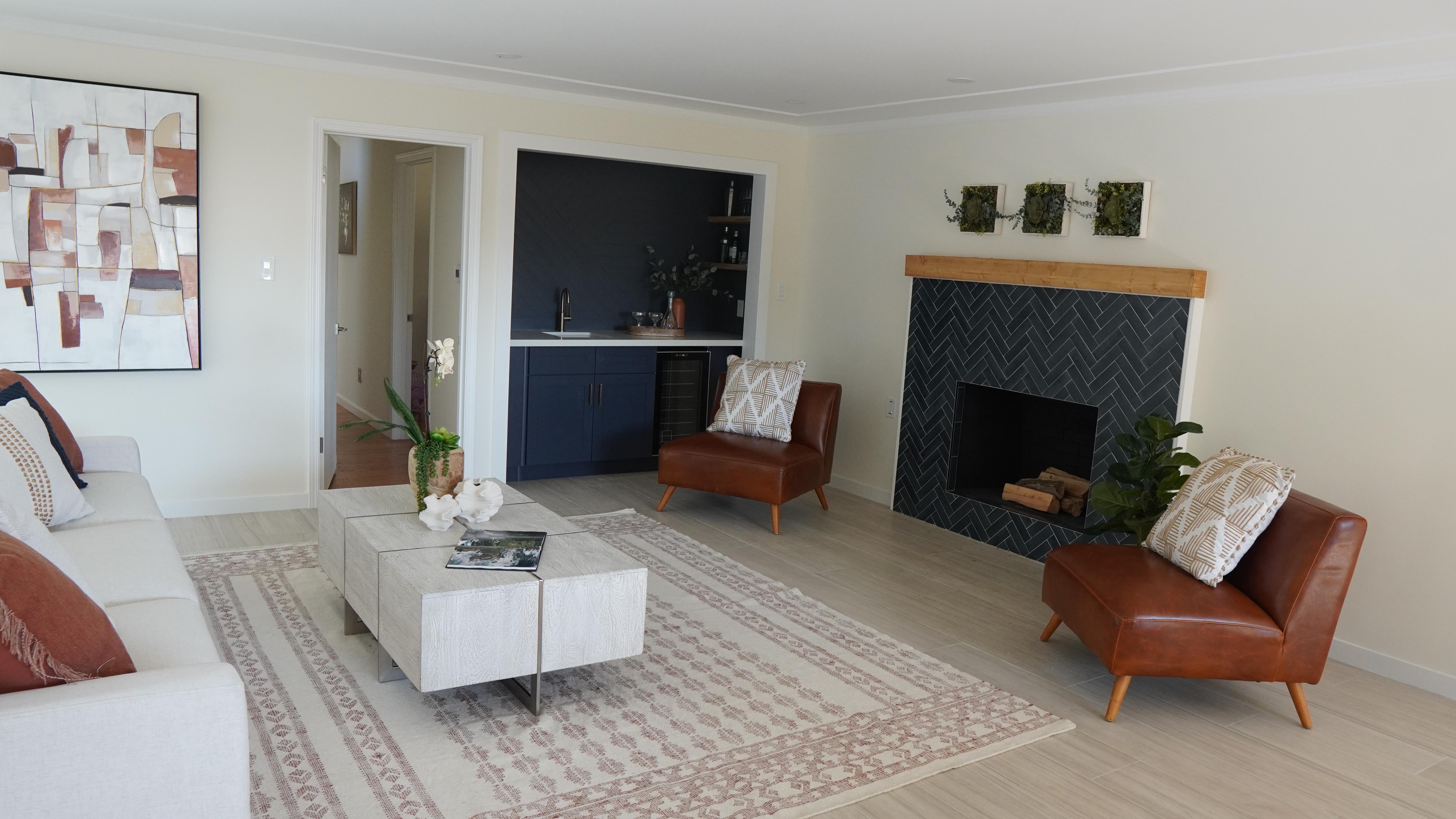 Living room remodel featuring a custom built-in bar, fireplace with blue tile surround, wood mantel, and modern finishes in Half Moon Bay California.