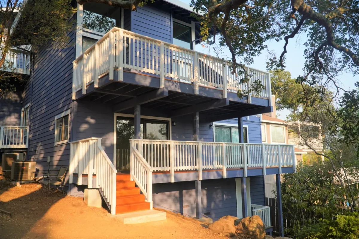 Doble deck construction featuring picket railings painted white and tropical decking planks in Novato, CA.  