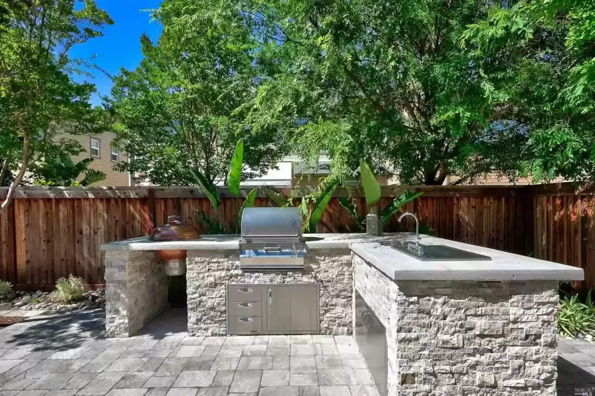 Back yard hardscape with concrete pavers, outdoor kitchen with natural stone veneer, and cement counter-tops in Novato, CA