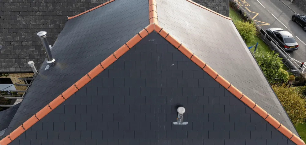 A grey slate roof with red ridge tiles that we installed in Hengoed