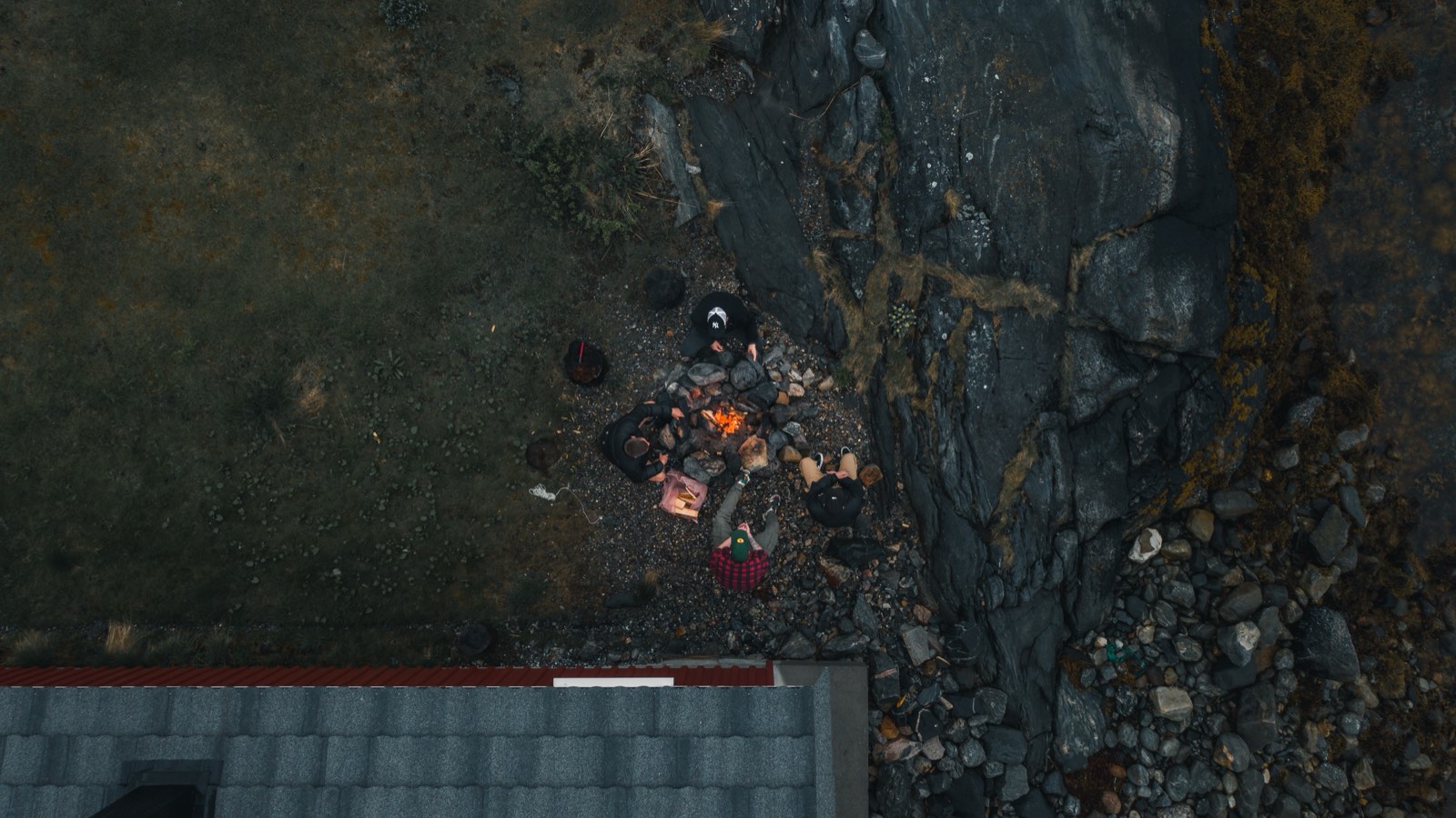 Drone view of a campfire gathering on a rocky Norwegian shore