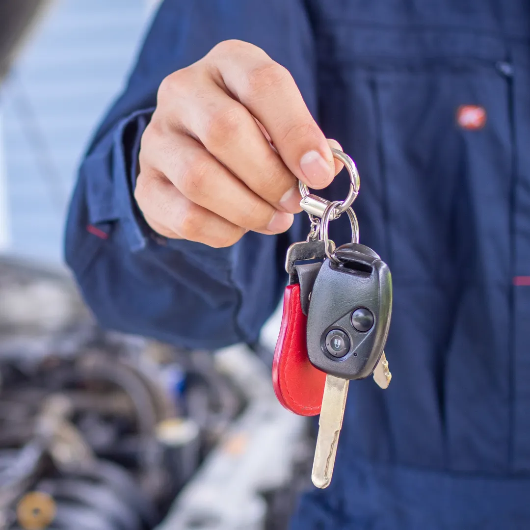 Close up of a hand giving the owner's keys back to them.