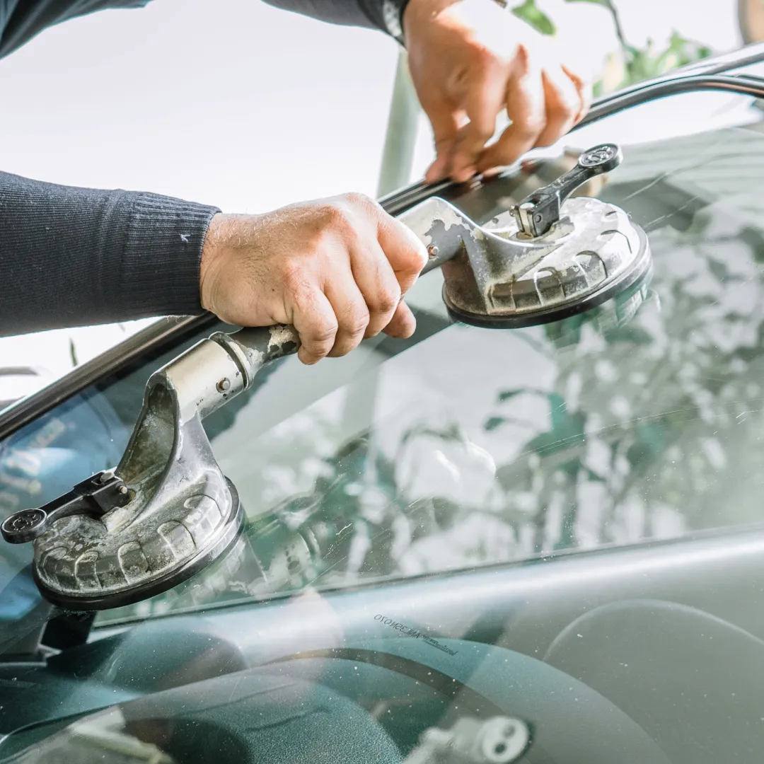 Close-up of a windshield replacement using advanced suction tools.