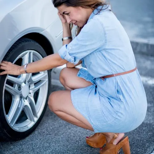 Woman worrying about flat tire