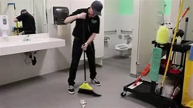 Hands cleaning a camera lens with a cloth.