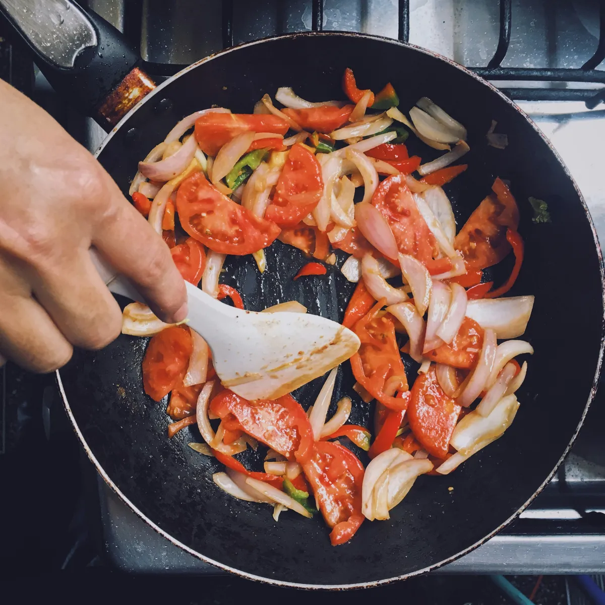 Hands preparing a pan of fresh vegetables