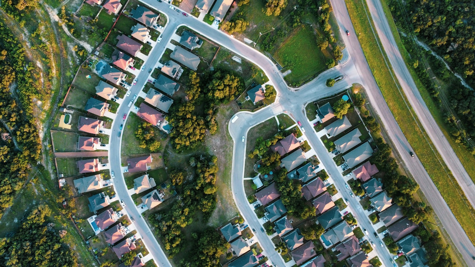Aerial view of a suburban neighborhood of homes and winding streets — the service area a contractor's city pages should describe