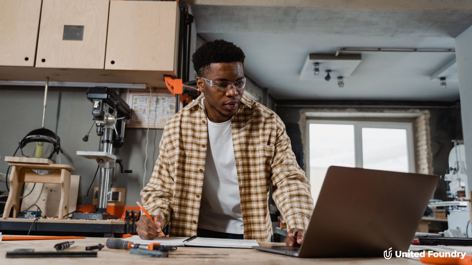 Contractor at a workbench reviewing their Google Business Profile settings on a laptop
