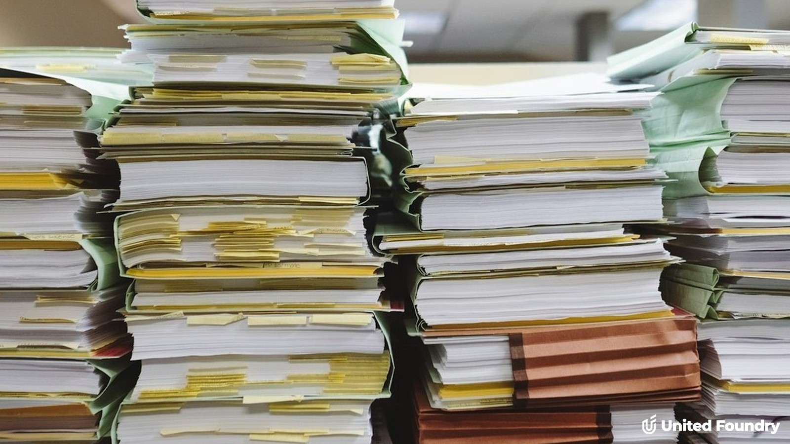 Stacks of tabbed file folders and documents, representing the license, insurance, and background-check paperwork Google requires for the Verified badge