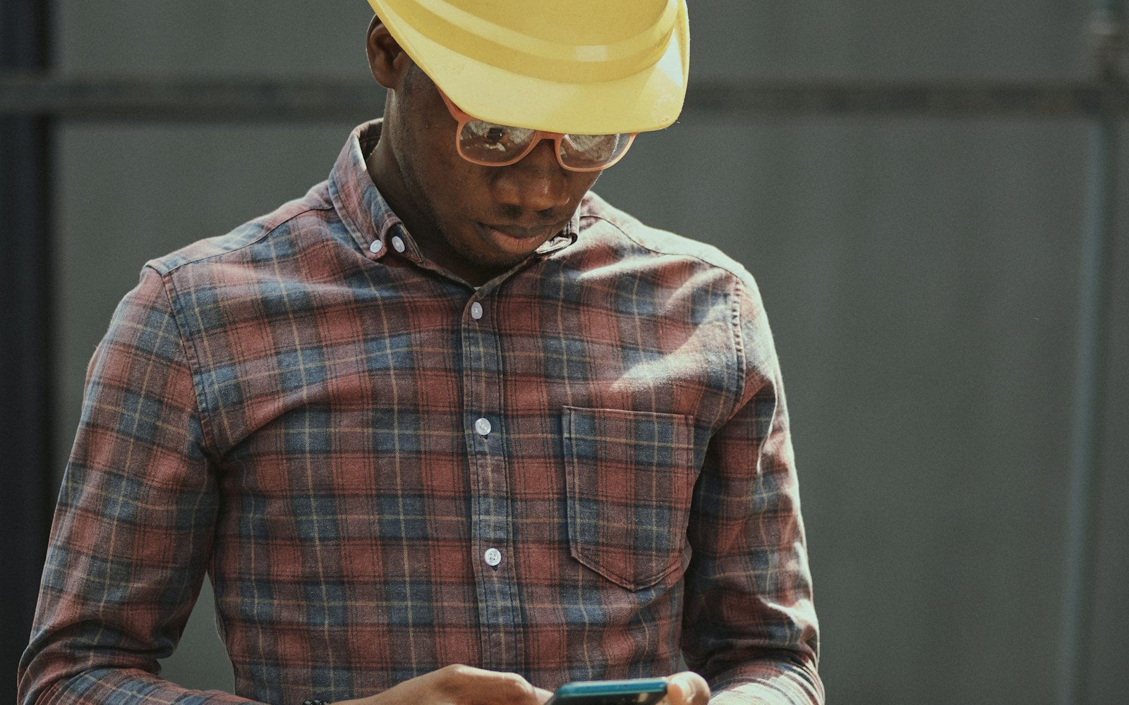 Contractor in a hard hat checking a lead call on his phone — Google LSA leads arrive as live calls