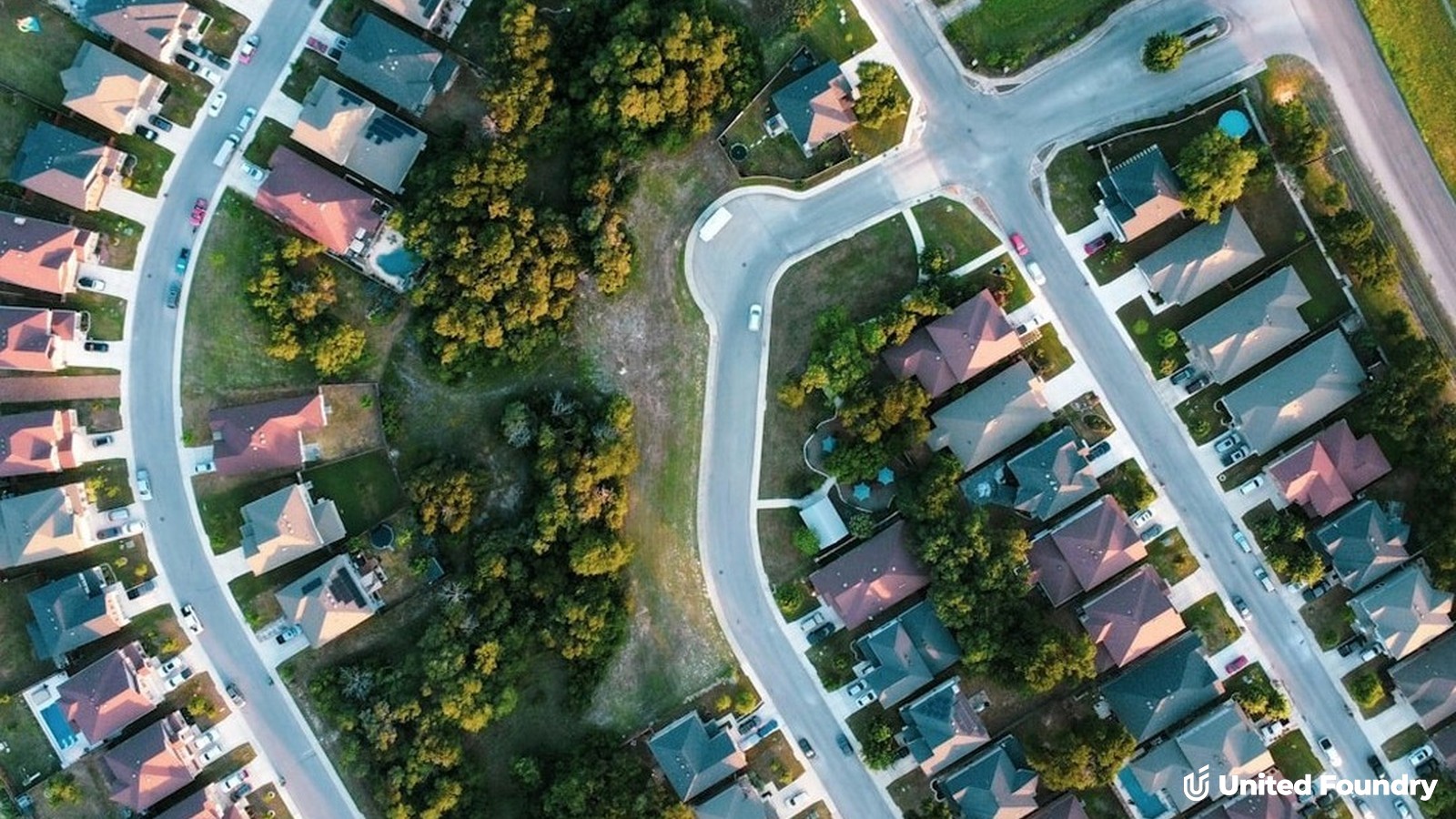 Aerial view of a suburban neighborhood of homes and winding streets — the service area a contractor's city pages should describe