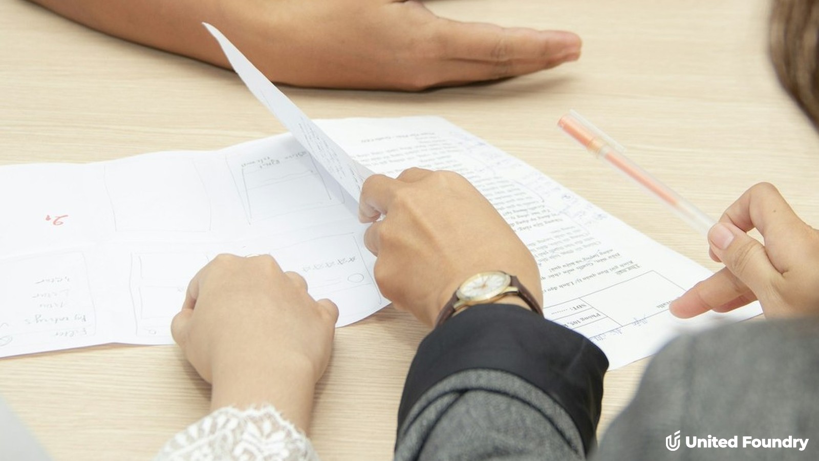 Contractor and clients reviewing two project estimates together at a table
