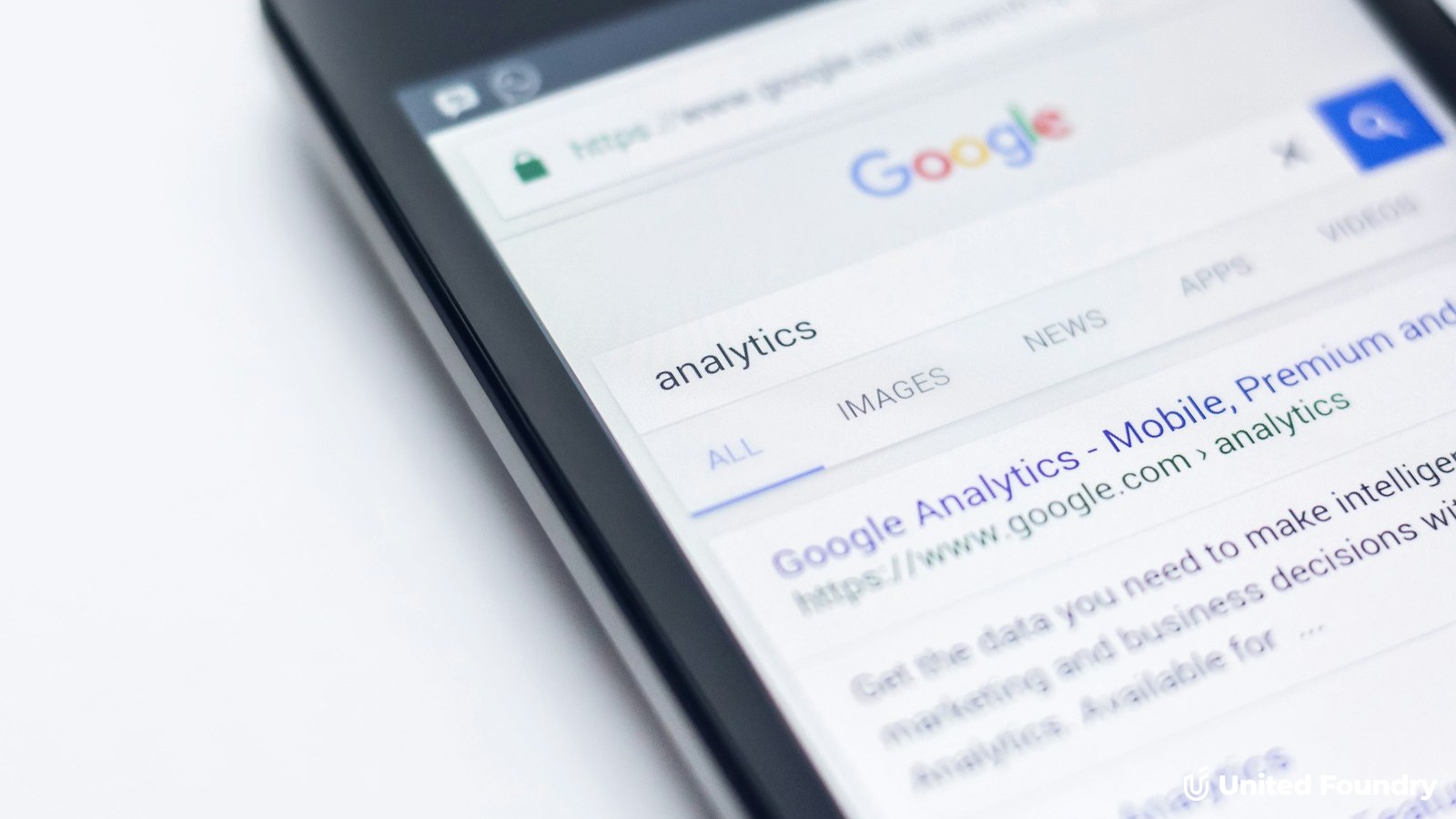 Close-up of a smartphone screen showing a Google search results page, United Foundry logo overlay