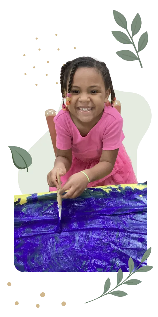 Smiling child painting a colorful artwork in a childcare classroom