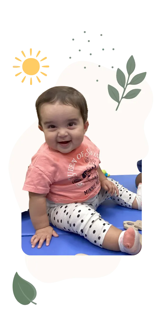 Smiling baby sitting and playing in a childcare classroom