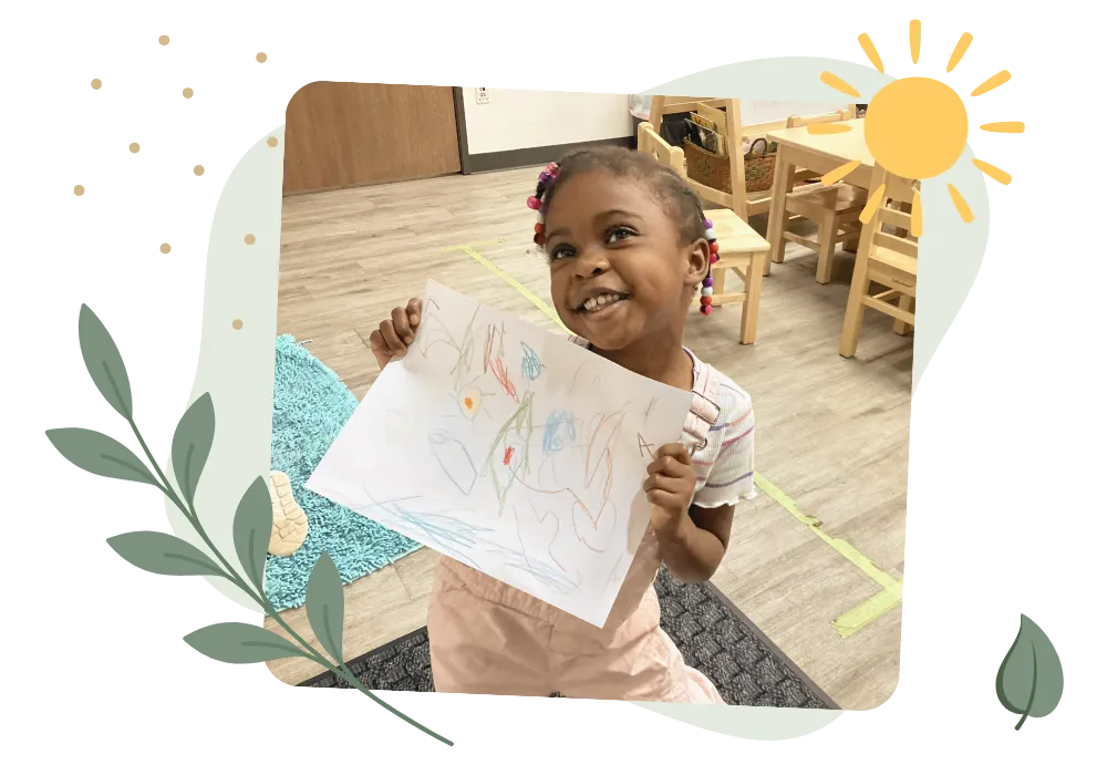 Young child proudly holding colorful artwork in a bright preschool classroom