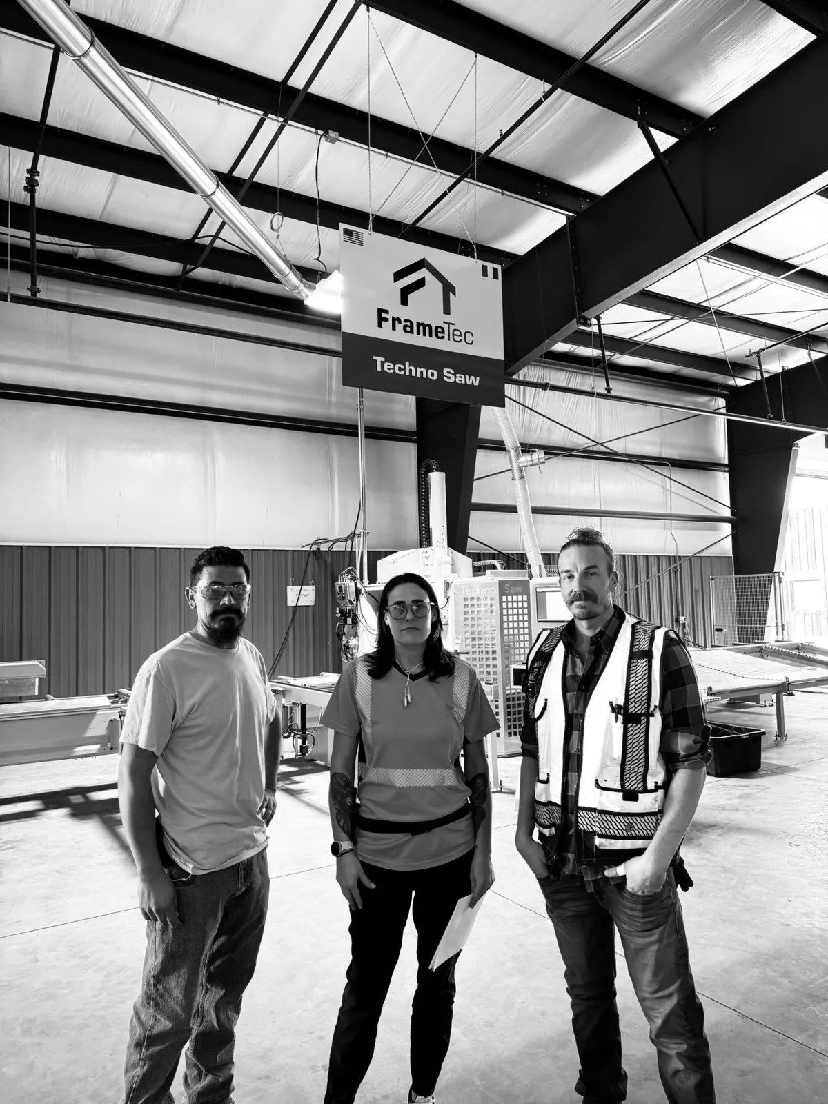 FrameTec manufacturing engineers collaborating in an automated framing production facility