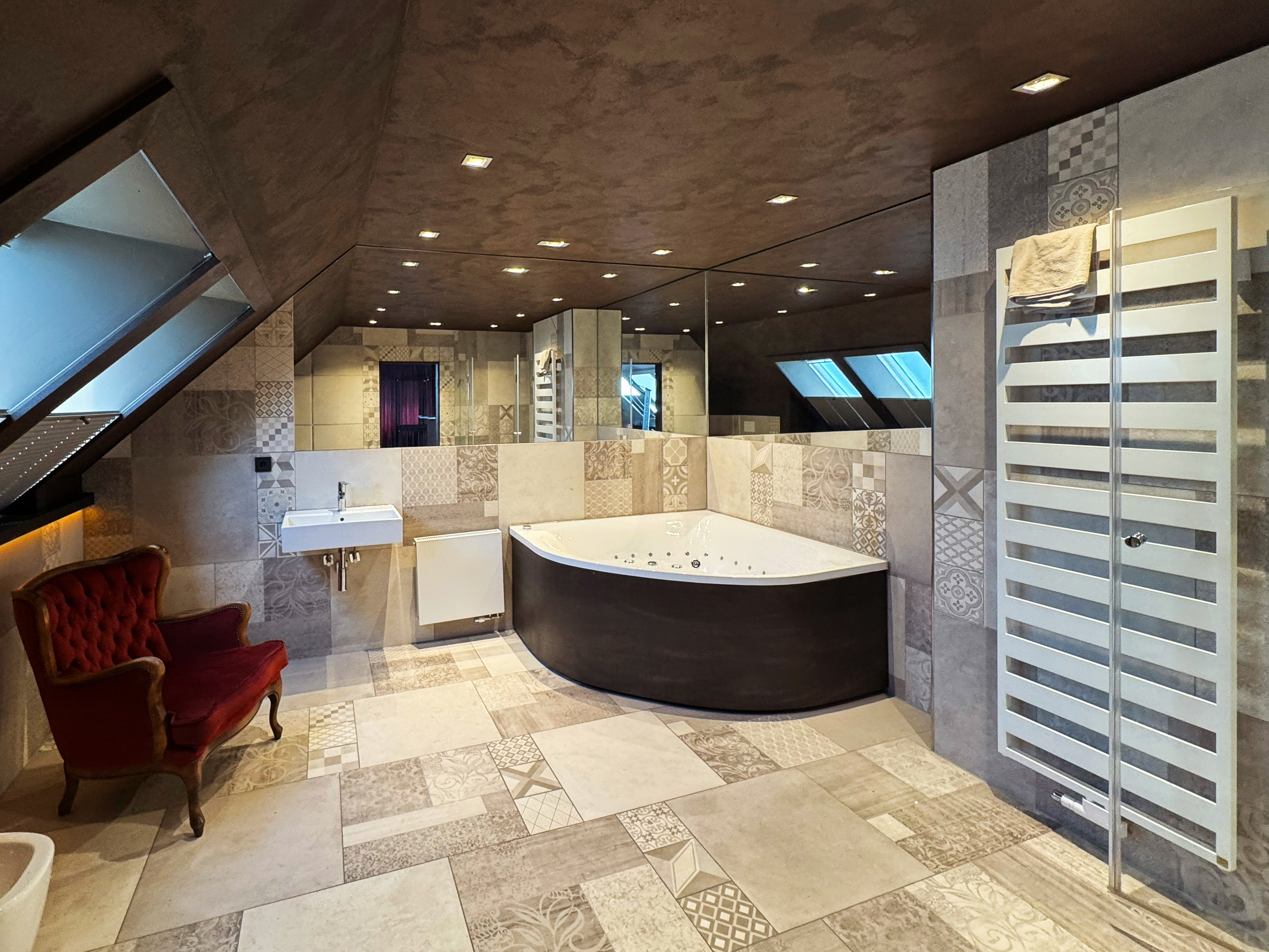 Großzügiges Badezimmer der Villa Amore Düsseldorf mit Whirlpool, Dusche und stilvoller Ausstattung
