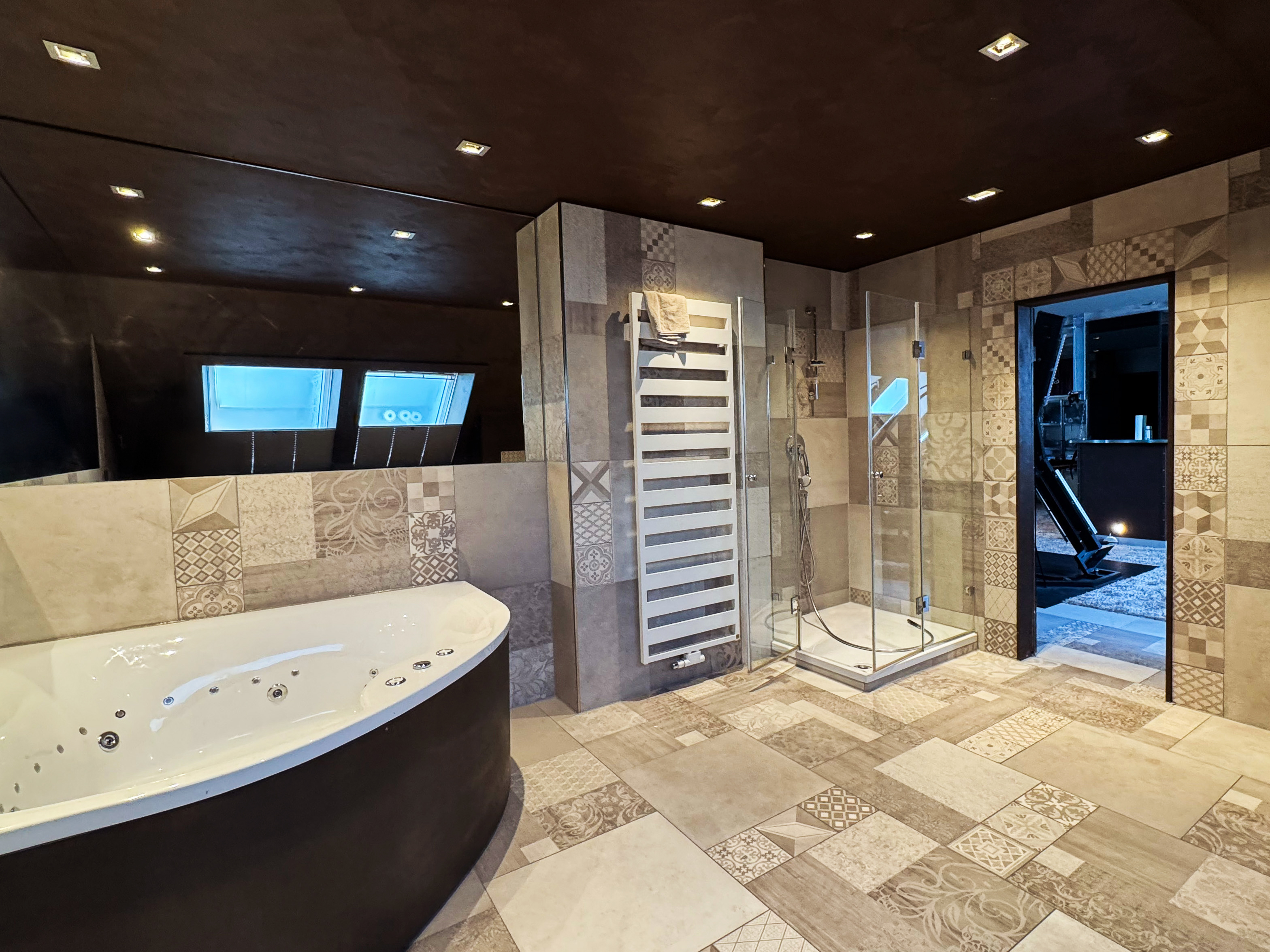 Großzügiges Badezimmer der Villa Amore Düsseldorf mit Whirlpool, Dusche und stilvoller Ausstattung