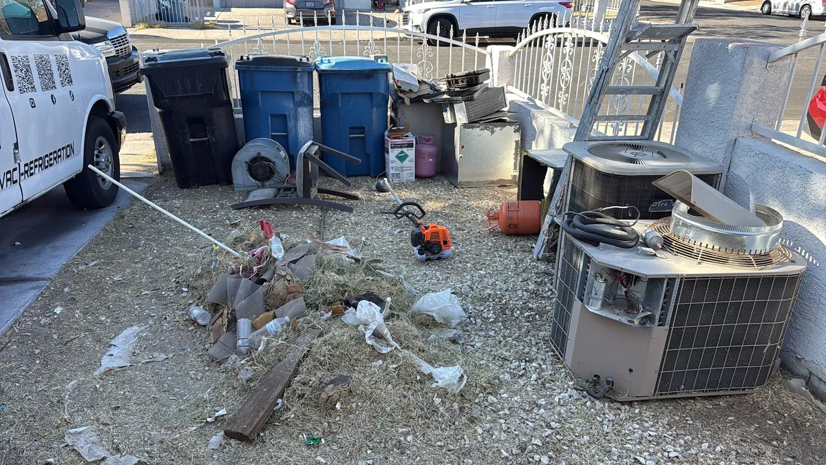 Yard full of debris and discarded items before cleanup