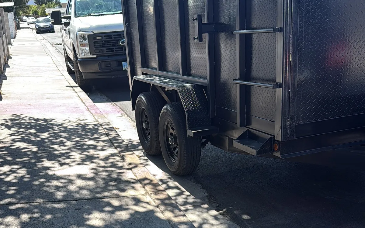 Dump trailer hitched to work truck on a hauling job