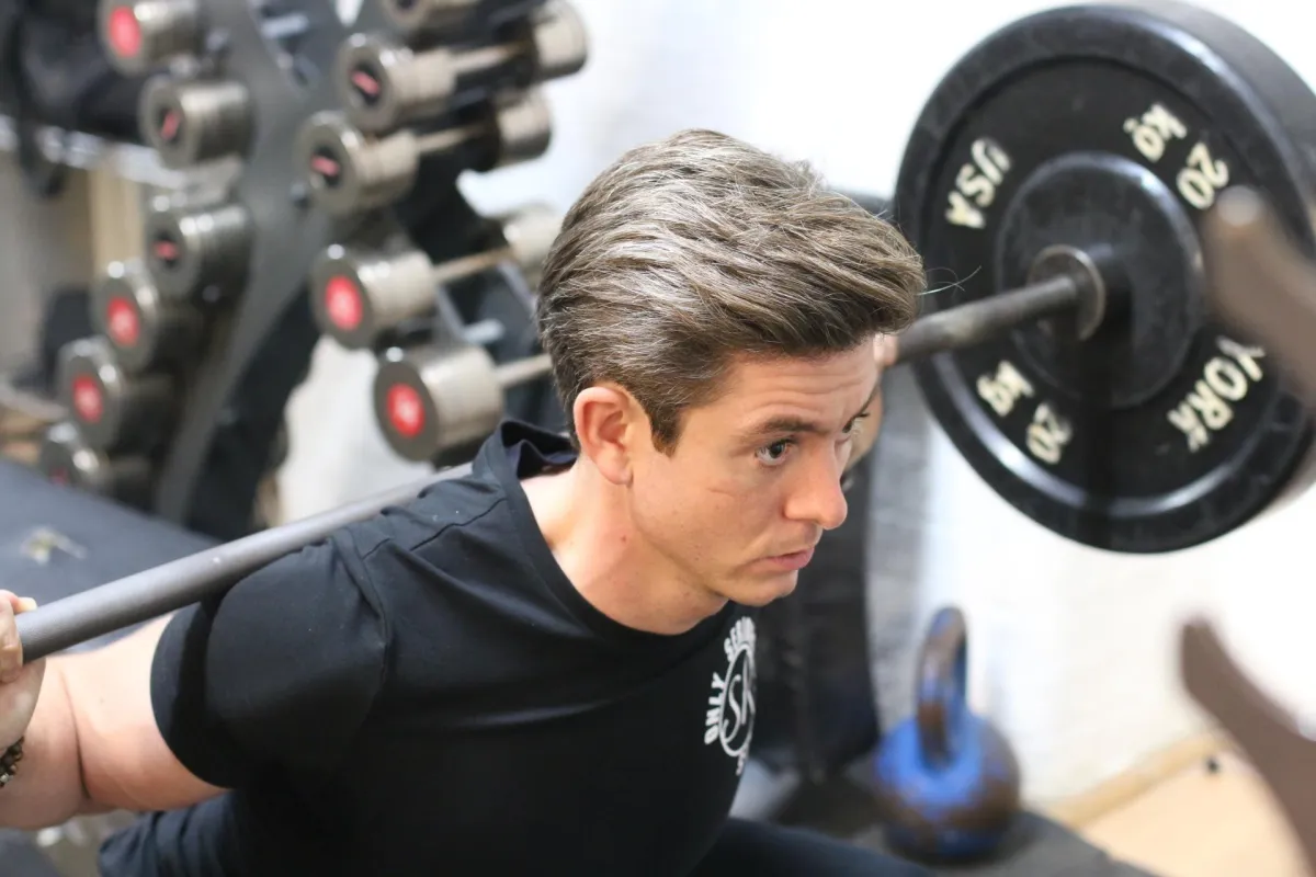 person standing beside black weights