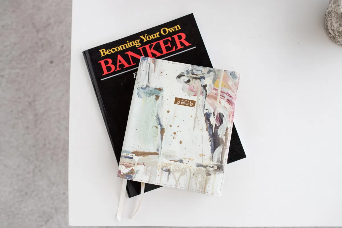 Finance book and Holy Bible stacked on a table