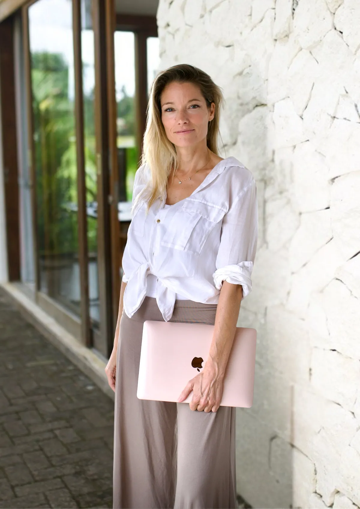 Fanny Schaetti in white linen against a white stone wall