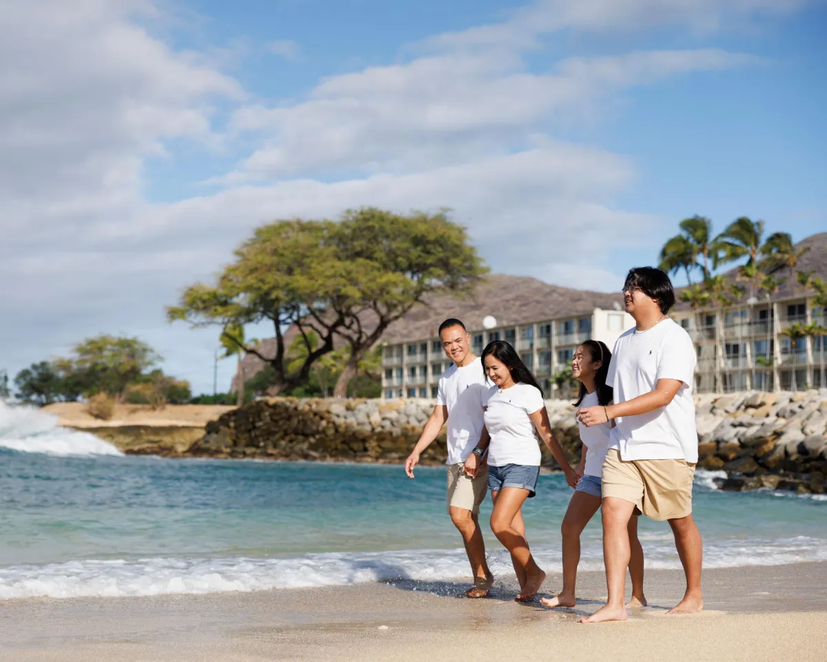 Family walking on beach in Hawaii. 