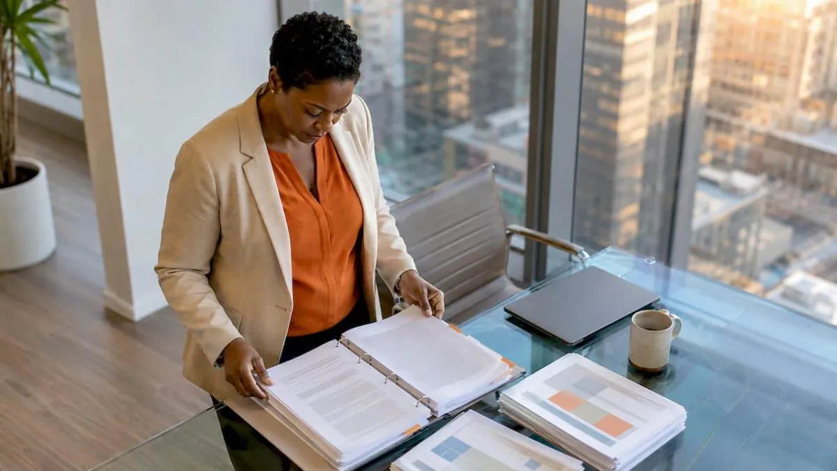 Contract manager reviewing compliance documents at table