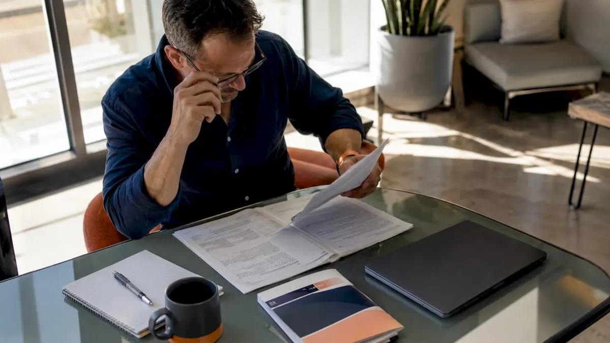 Small contractor reviewing government bid documents at desk