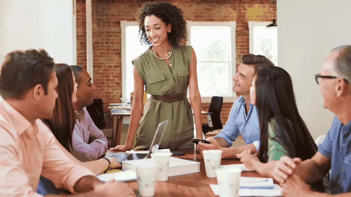 Female business owner leading a team meeting, symbolizing the successful transition from field work to strategic corporate leadership and scaling the business