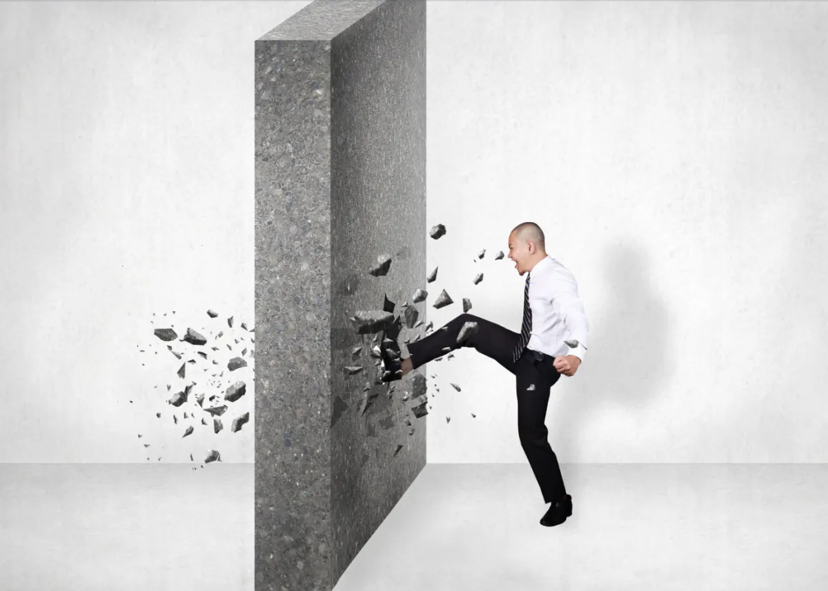 Professional breaking through a barrier representing common gaps that get in the way of managing up effectively.