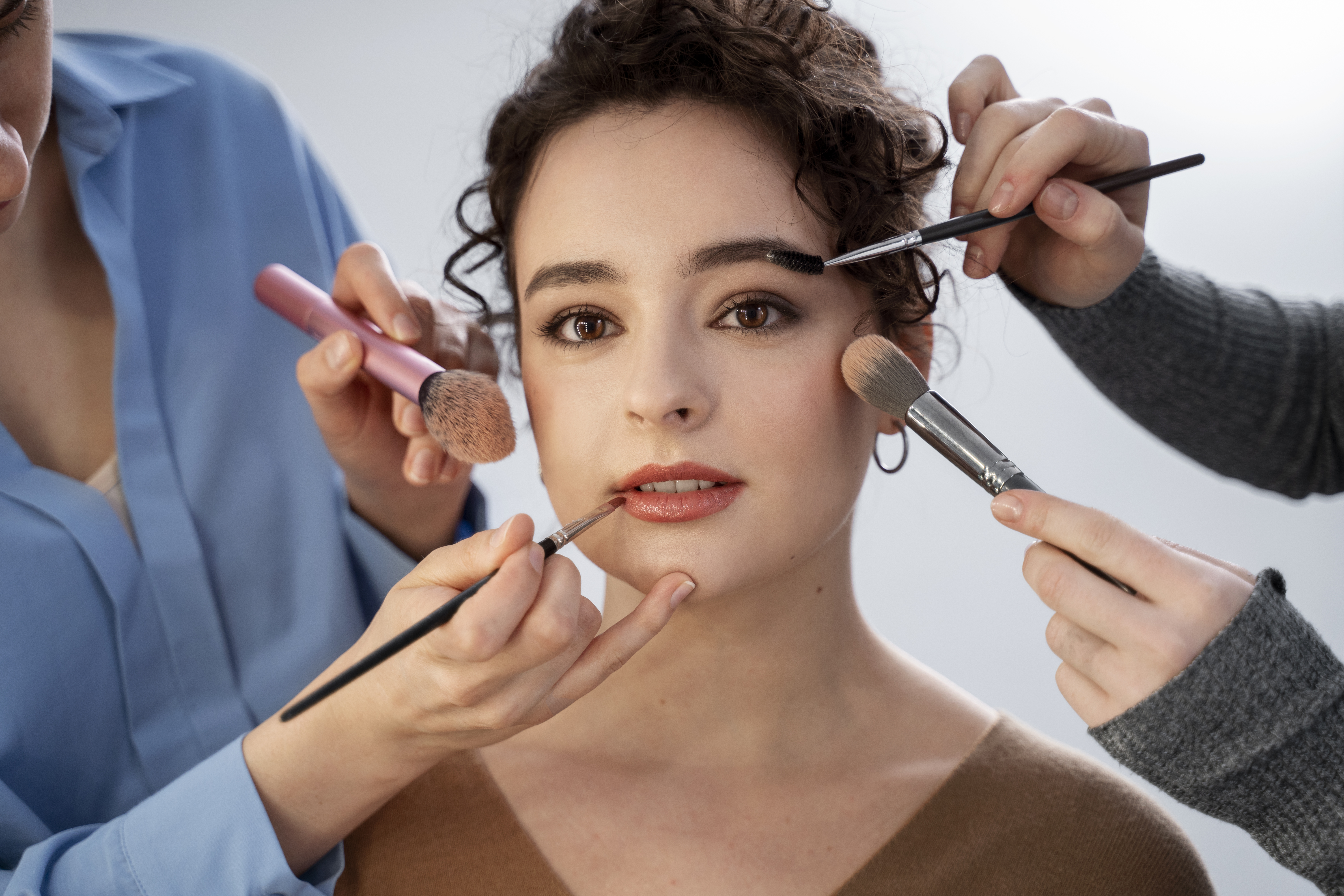 Beauty students applying makeup techniques during cosmetology trainingv