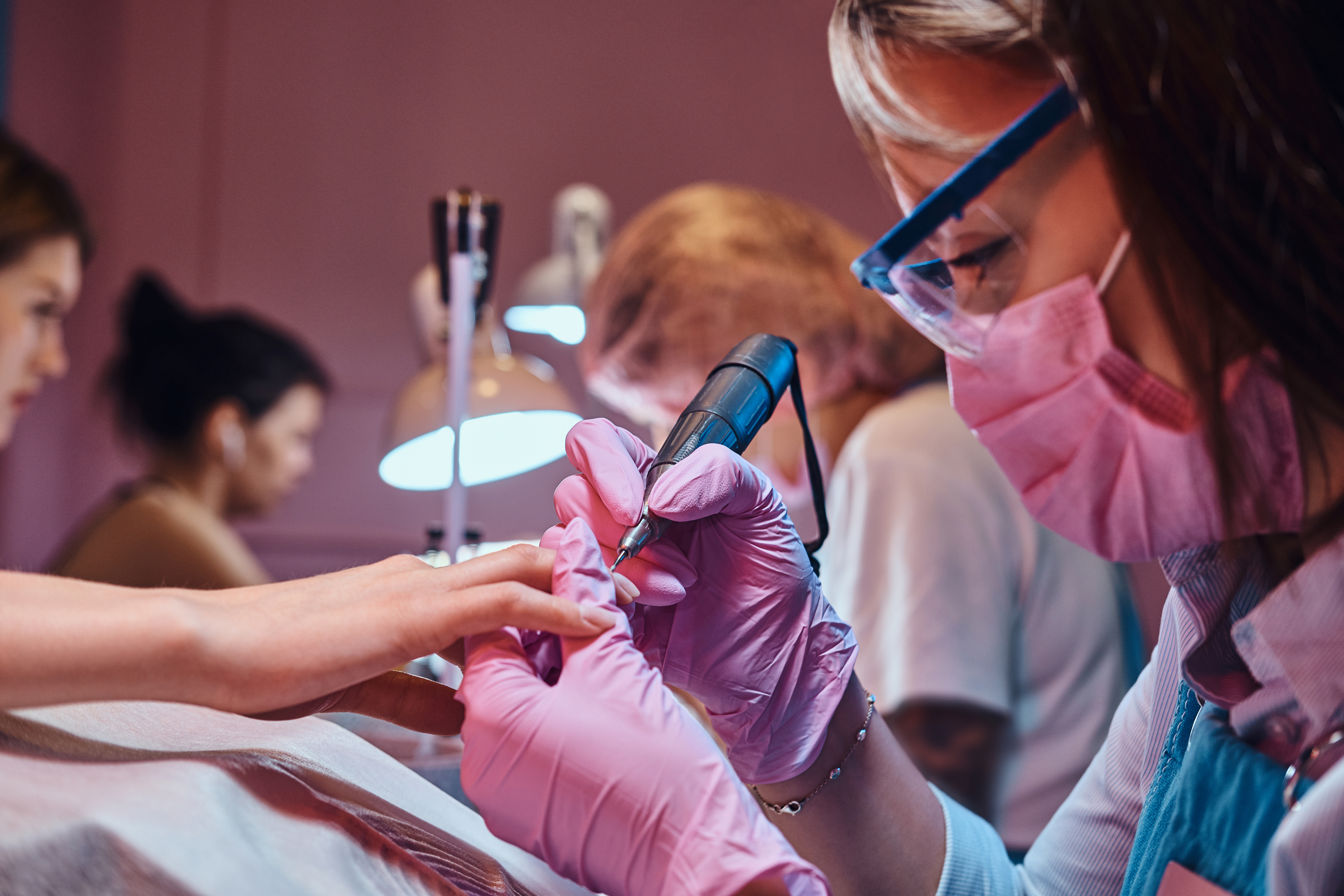 Nail technician student performing a manicure during nail technology training