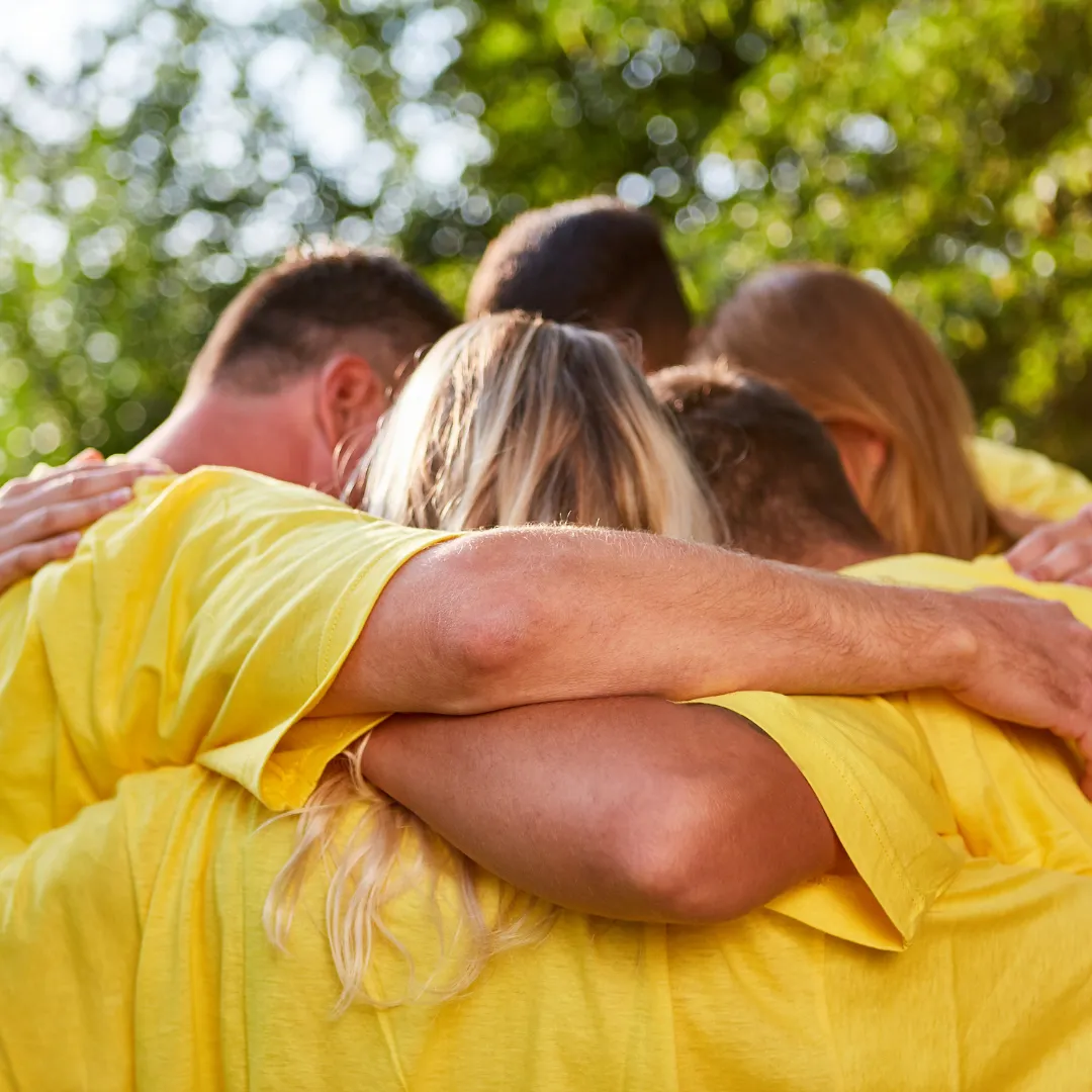Group of people at feel day hugging and strategizing for game time