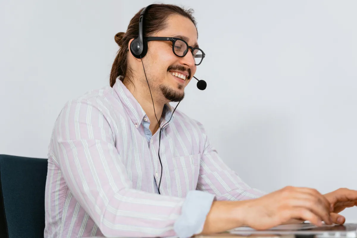 a man sitting at a desk talking on a cell phone