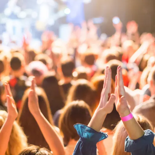 Two people standing by the ocean with rocks.