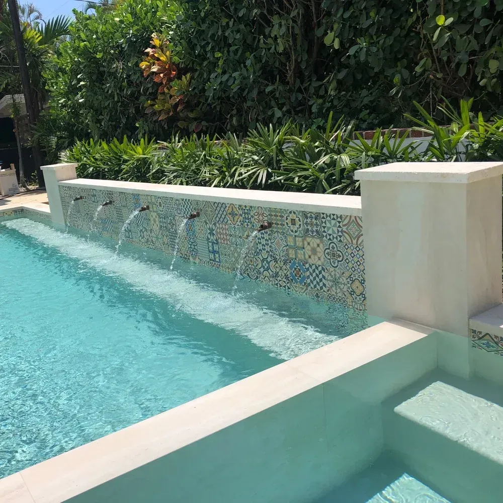 Custom water feature and fountain installation for residential pool - cascading waterfall design by Gables Pool Miami