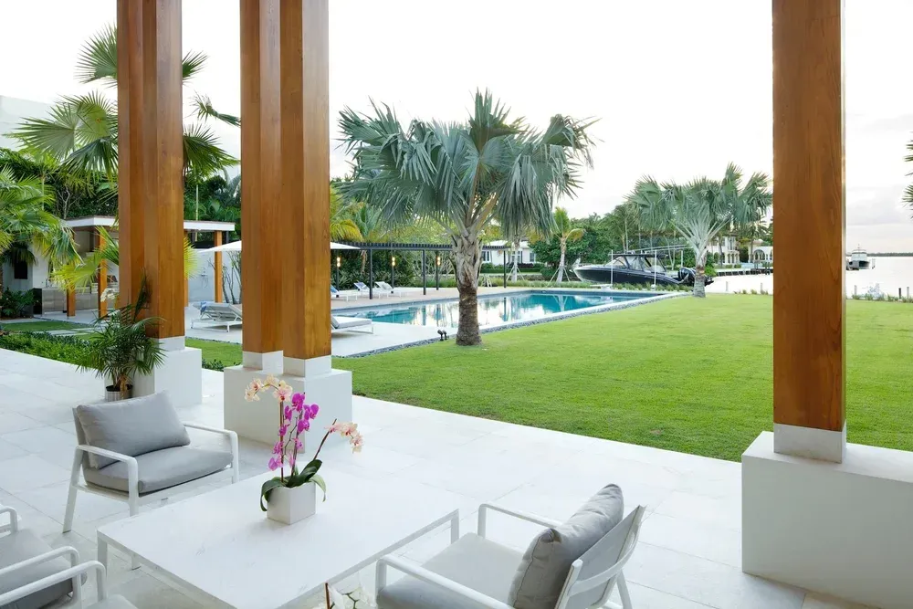 Luxury outdoor pool area with palm trees and modern patio furniture - Gables Pool construction and design services