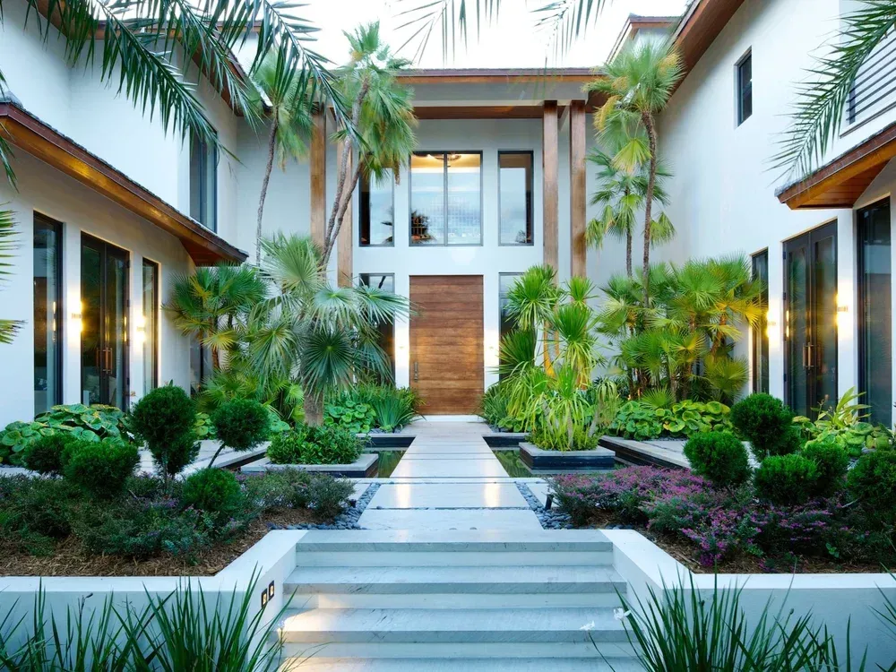 Luxury outdoor oasis with waterfall and lush landscaping - backyard design and construction by Gables Pool Miami