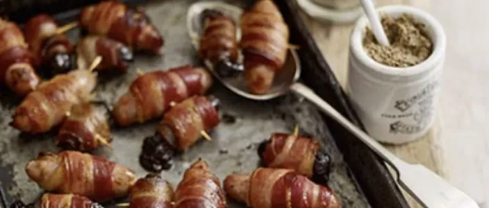 Prune wrapped in bacon and sausage
