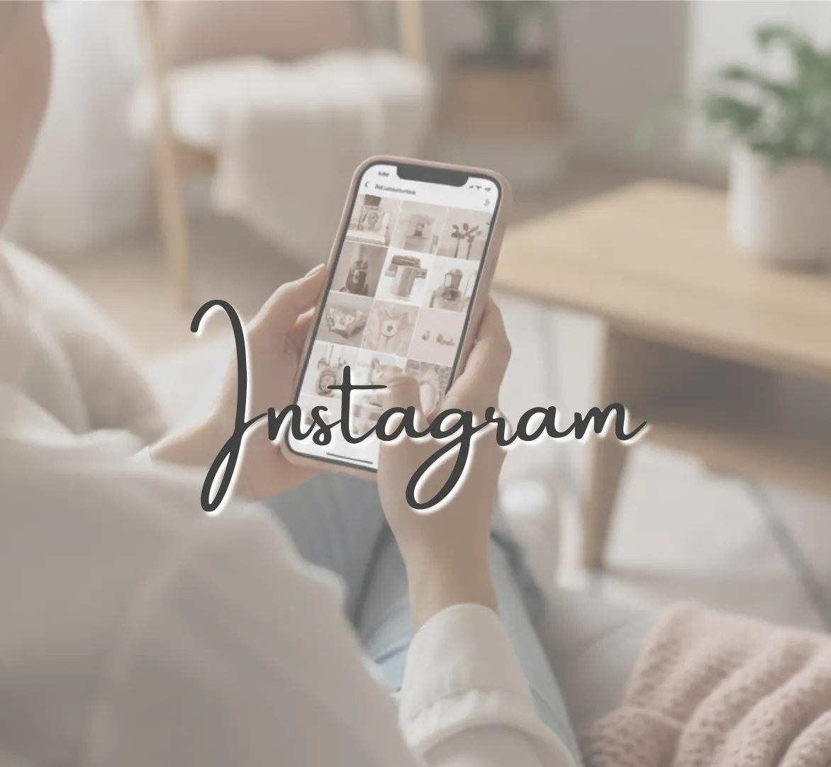 Looking over the shoulder of a woman sitting on a couch scrolling social media on her cellphone