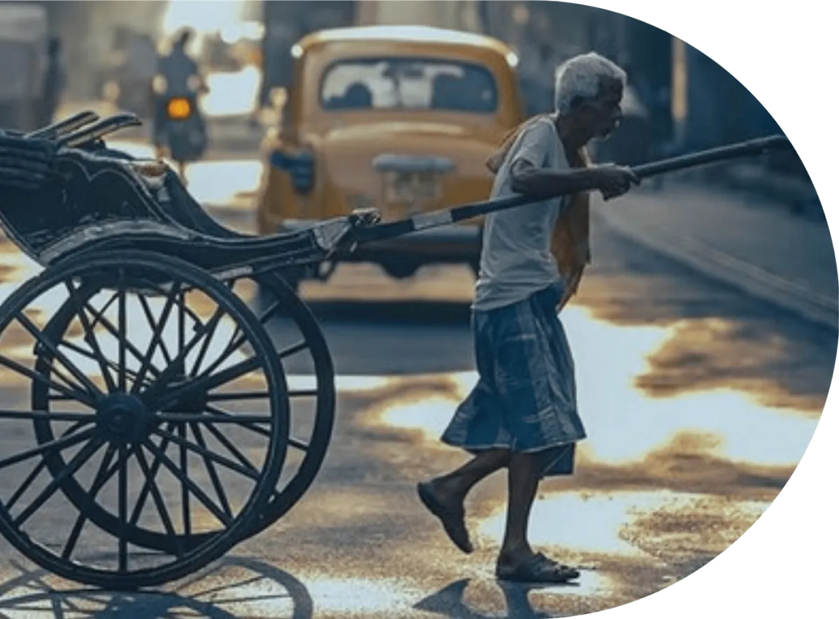 A rickshaw puller walking a wet street in India